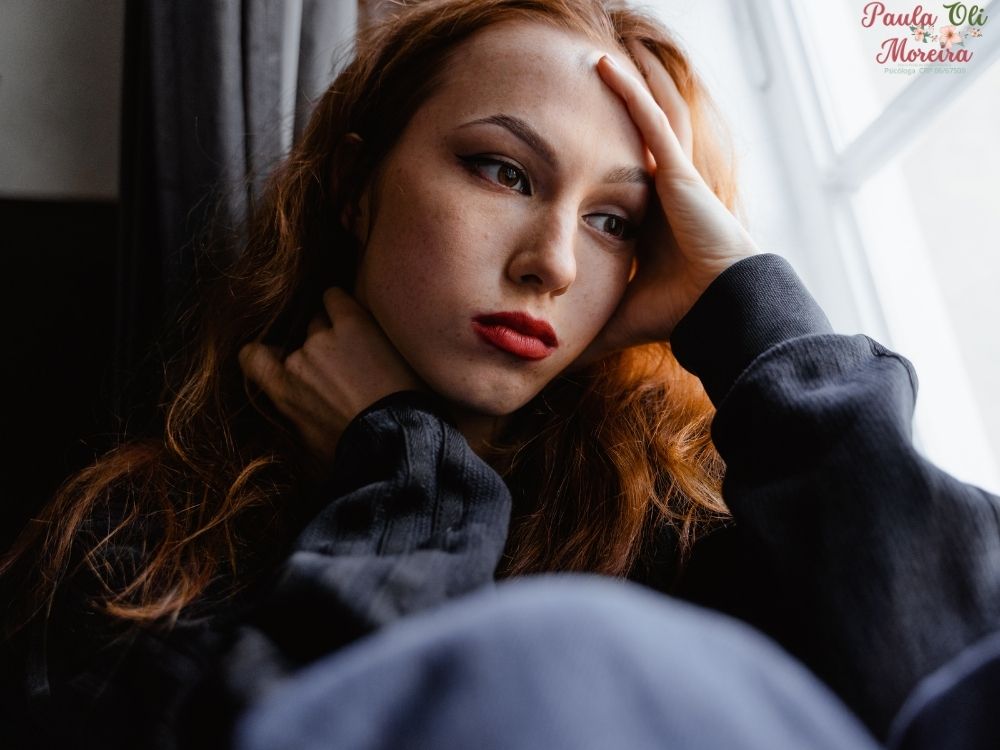 mulher ao lado da janela triste pensando