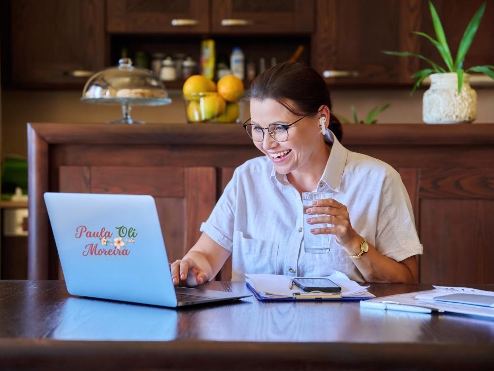 Mulher frente ao computador fazendo terapia online e sorrindo
