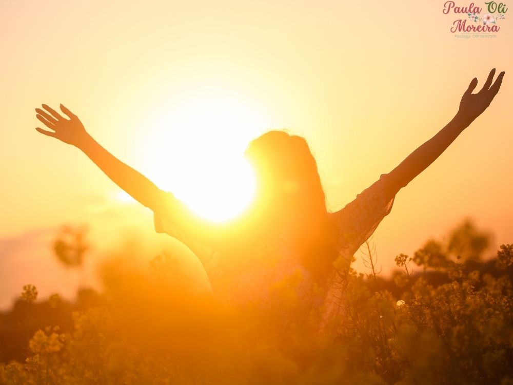 mulher frente ao por do sol feliz depois de se livrar dos pensamentos negativos