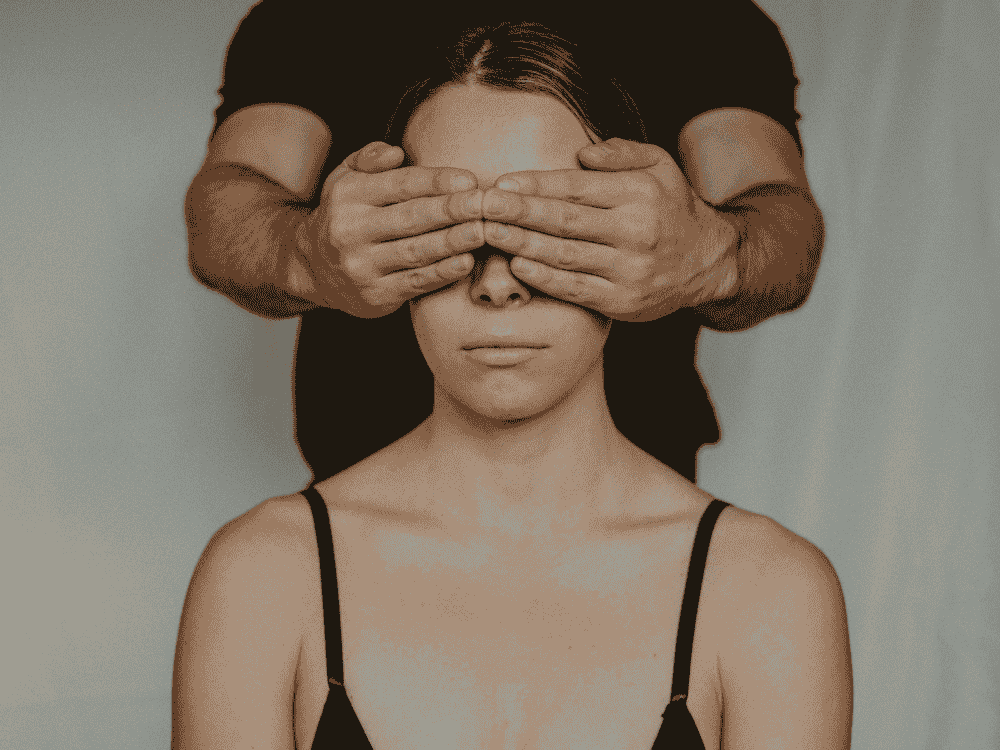 Menina com mãos de homem nos olhos -dependência emociona -Fonte: Canva