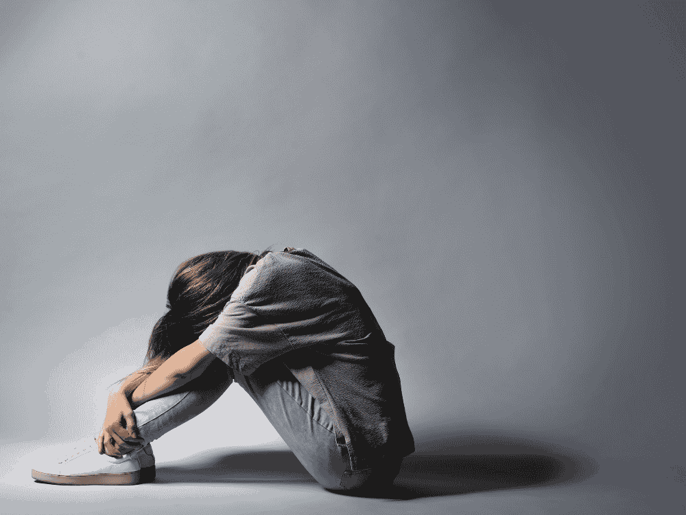 Mulher solitária em posição fetal- Dependência emocional- imagem: Canva